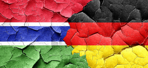Gambia flag with Germany flag on a grunge cracked wall