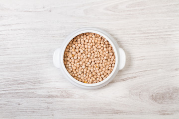 Garbanzos en cuenco blanco sobre madera vista de arriba. Copy space