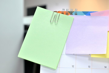 Post-it notes on calendar at workplace with copy space for text.