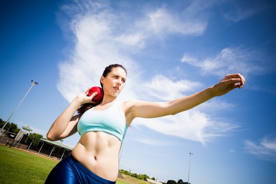Female athlete preparing to throw shot put ball - Powered by Adobe
