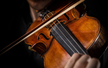 Detail a violinist playing his instrument