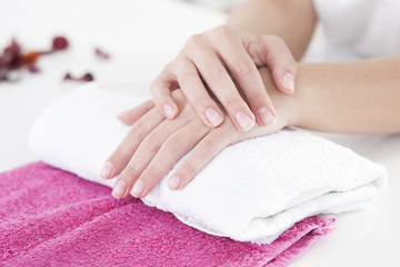 Obraz na płótnie Canvas Beautiful woman hands on a towel in manicure salon