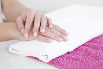 Obraz na płótnie Canvas Beautiful woman hands on a towel in manicure salon