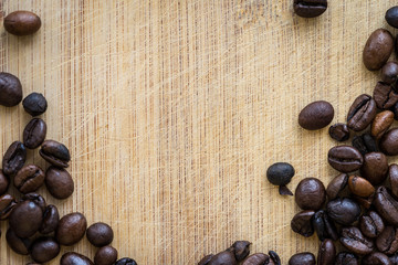 Top view of roasted coffee beans on a wooden table. Horizontal shot of coffee beans. Wooden board with texture.