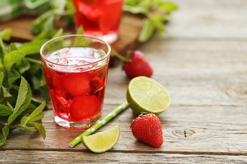 Fresh strawberry drink in glass with lime on wooden table