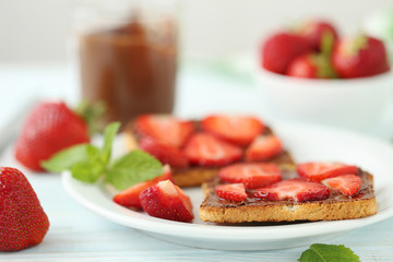 French toasts with chocolate and strawberry on wooden table