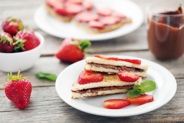 French toasts with chocolate and strawberry on wooden table