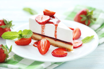 Strawberry cheesecake on plate on blue wooden table