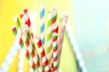 Striped drink straws on a colorful wooden background