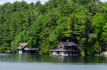 Fototapeta na wymiar Two boathouses on a lake in Muskoka, Ontario