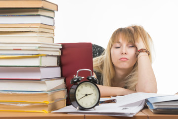 Student fell asleep leaning his head on his hand, late at night in preparation for the exam