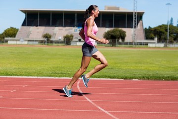 Obraz premium Female athlete running on the running track
