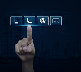 Hand pressing telephone, mobile phone, at and email buttons over