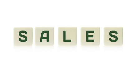 Word "Sales" on board game square plastic tile pieces, isolated on a white background.