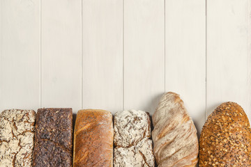 Rząd smacznych chlebów jasnych i ciemnych z pełnego ziarna - tło kompozycja piekarnicza