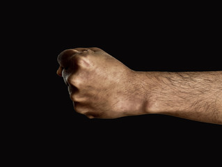 Man hand fist on dark background