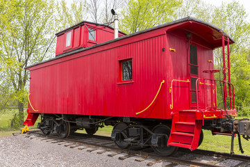 Fototapeta na wymiar Red Wooden Railroad Caboose On Train Track