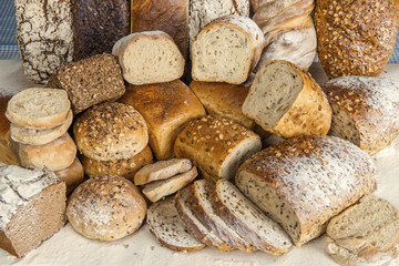 Chleby w piekarni jasne i ciemne, obsypane ziarnami i mąką