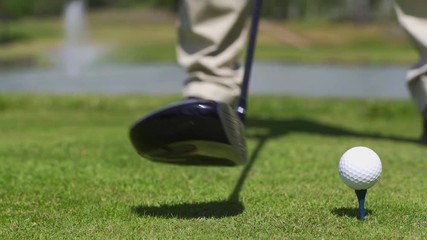 Closeup of a golfer teeing off with his driver