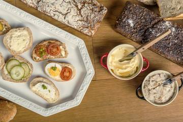 Fototapeta na wymiar Gotowe kanapki z pełnoziarnistego chleba, z masłem, smalcem, pomidorem, szczypiorkiem, ogórkiem i jajkiem