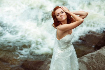 Fototapeta na wymiar Bride pose in the front of a foaming mountain river