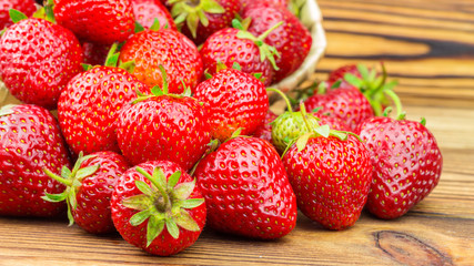 Full basket of strawberries that are poured out on table