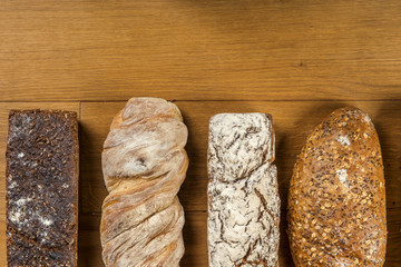 Chleby z pełnego ziarna obsypane mąką na drewnianym tle