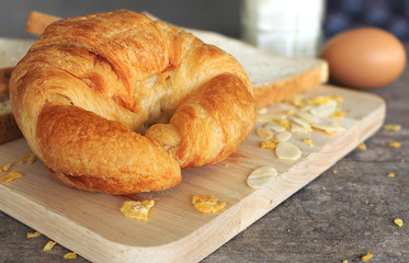 croissant bread on wood table background, over light [blur and select focus background]