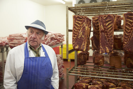 Portrait Of Butcher Standing In Cold Store With Prepared Meat