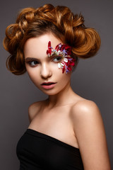 Beautiful girl with creative make-up with floral appliques. The model in the style of romantic with flower petals around her eyes. The photo was made in a studio. Beauty face