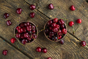 Ripe cherries in a clay bowl on wooden background