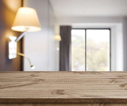Empty wooden table on defocused simple hotel room interior background