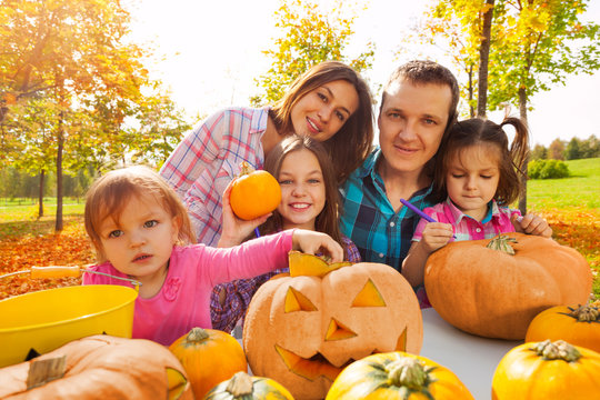 Happy family carving pumpkins prepare to Halloween