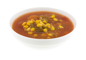 Corn okra and tomatoes in a white bowl isolated on a white background side view.