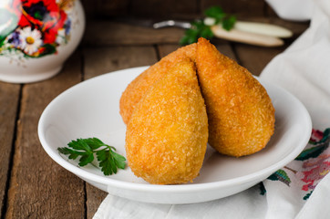 Chicken cutlets in breadcrumbs - Chicken Kiev in white bowl on wooden background. Ukrainian cuisine. Selective focus