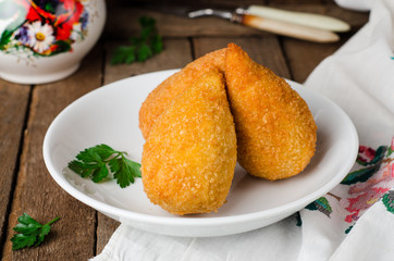 Chicken cutlets in breadcrumbs - Chicken Kiev in white bowl on wooden background. Ukrainian cuisine. Selective focus