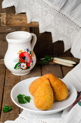 Chicken cutlets in breadcrumbs - Chicken Kiev in white bowl on wooden background. Ukrainian cuisine. Selective focus