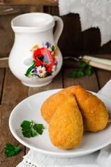 Chicken cutlets in breadcrumbs - Chicken Kiev in white bowl on wooden background. Ukrainian cuisine. Selective focus