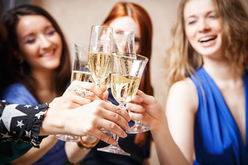 Group of beautiful young women with glasses of champagne celebrating New Year