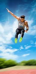 Fototapeta na wymiar Sportsman jumping against athletics field 
