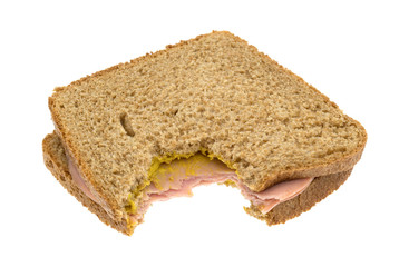 Mortadella sandwich on wheat with mustard bitten isolated on a white background.