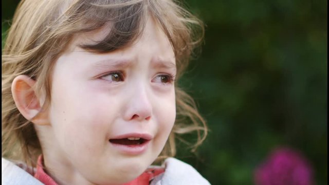 Portrait of a sad and crying curly little girl