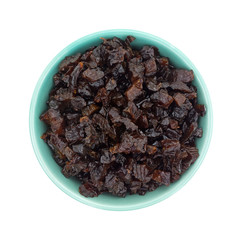 Diced prunes in a bowl isolated on a white background top view.
