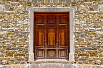 Mediterranean style wooden door on stone wall