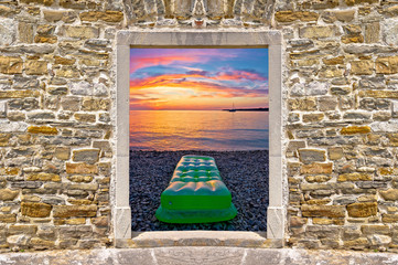 Sunset on beach through stone wall door