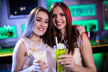 Portrait of beautiful women holding cocktail glasses