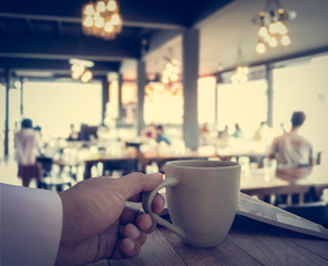 Hand of business man holding coffee cup
