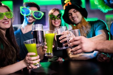 Group of friends toasting beer mugs and drink glasses