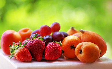Ripe strawberries, apricot and medlars in table