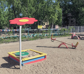 Children's playground in the sand . Sandbox and canopy in the form of daisies . Swing